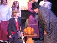 Tony Filipone as Scrooge, Don Gimpel as Bob Cratchit, Anne Lannak as Mrs. Cratchit and Cole Cucinotta as Tiny Tim. Also pictured are Michael Godfrey as Peter Cratchit, Zoe Pratt as Cratchit Daugher and Portia Lannak as Belinda Crachit. (Photo courtesy of Footlighters Theater)